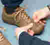 close-up of male hands checking the fit of shoes on a male subject